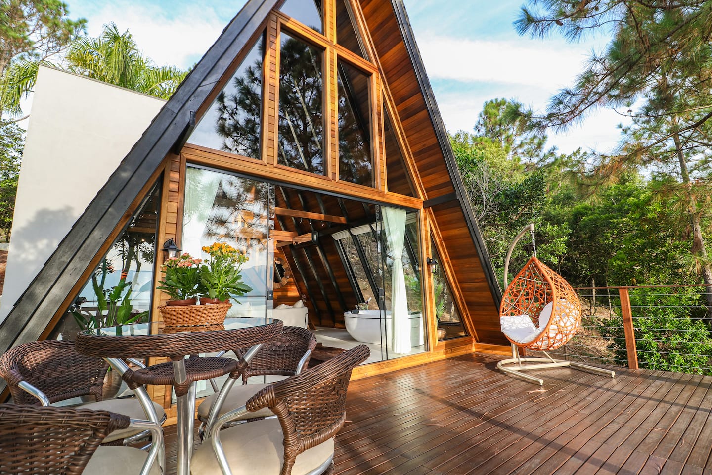 Fachada do chalé A-frame em meio à mata